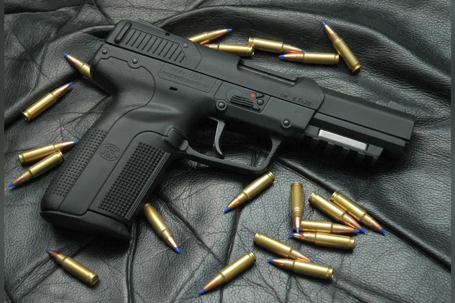 Five-seveN USG (wcześniejsza odmiana) i zawartość standardowego magazynka: 20 nabojów 5,7×28 mm